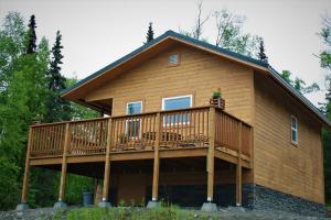 a house with a large deck on the side of it at Grace and Bill's Freedom Hills B&B in Talkeetna