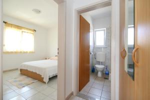 ein Schlafzimmer mit einem Bett und ein Badezimmer mit einer Toilette in der Unterkunft Apartments Antea in Rogoznica + 122 Fotos