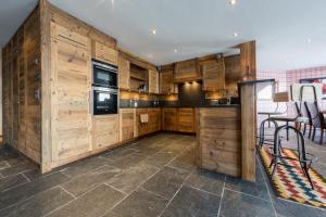 a kitchen with wooden cabinets and a stove top oven at La Cordée 4 - Spa Access - Mer de Glace complex in Nendaz