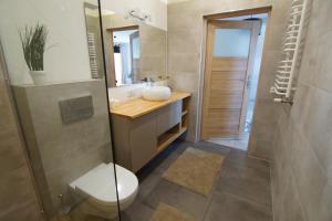 Un baño con inodoro, lavabo y ducha. en Apartament Kropla Bałtyku 16 Darłówko, en Darłówko 9 fotos más