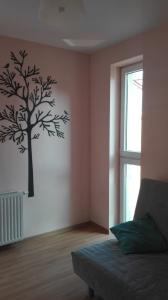 a bedroom with a tree stenciled on the wall at Amelia in Świnoujście