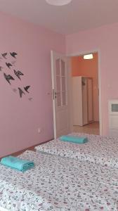 duas camas num quarto cor-de-rosa com morcegos na parede em Amelia em Świnoujście
