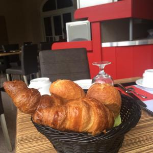 ein Korb mit Croissants auf einem Tisch in der Unterkunft Hotel Parc & Lac in Montreux