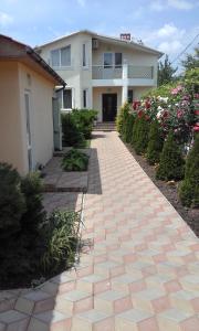 a brick walkway in front of a house with flowers at Cozy House on Vanceti Street in Odesa