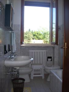 a bathroom with a sink and a toilet and a window at Hotel Valle Intelvi in San Fedele Intelvi