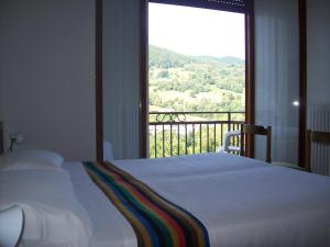a bedroom with a bed and a large window at Hotel Valle Intelvi in San Fedele Intelvi