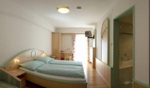Postel nebo postele na pokoji v ubytování Hotel zum Kirchenwirt Mariazell + 35 fotografií