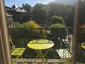 エクスレバンにあるSuite Grand Hotel Palace Aix les Bains French Alpsの黄色のテーブルと椅子が備わるバルコニー