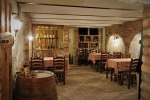 a restaurant with tables and chairs in a room with brick walls at Halász Airport Panzio in Vecsés
