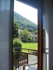 balcón con silla y vistas a la montaña en Hotel Valle Intelvi, en San Fedele Intelvi