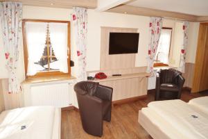a hotel room with two beds and a television at Hotel Gute Quelle in Beilstein