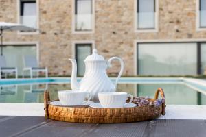 uma bandeja com um bule de chá e chávenas numa mesa em Casa de Belharino em Miranda do Douro