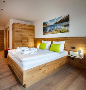 Un dormitorio con una gran cama de madera con almohadas verdes en Das Heimsitz, en Brixen im Thale