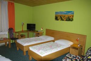 a hotel room with two beds and a desk at Pension Duel in Ústí nad Labem