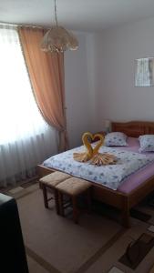 Un dormitorio con una cama con dos cisnes. en Pensiunea Claudiu, en Caransebeş