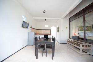 a dining room with a table and a bed at Pondok Anastasia in Ubud