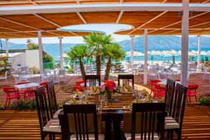 a restaurant with tables and chairs on a deck at Hotel Royal in Vlorë