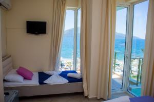 a room with a bed with a view of the ocean at Hotel Royal in Vlorë