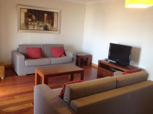 - un salon avec un canapé et une télévision dans l'établissement Corcovada, Albufeira, Algarve, à Albufeira
