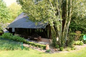 a gazebo with a bench next to a tree at Comme une parenthèse au coeur des hortillonnages in Amiens
