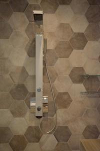 um chuveiro na casa de banho com azulejos castanhos em Panorama Hotel em Klima