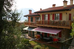 een huis met een balkon met een tafel en stoelen bij Residenza Cristina in Brenzone sul Garda