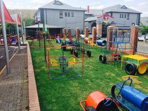 a playground with a bunch of play equipment on the grass at Picanha Grill Guest House & Events Venue in Nigel