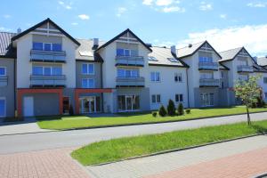 una fila de casas al lado de una calle en Apartament Kropla Bałtyku 16 Darłówko, en Darłówko