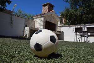 una pelota de fútbol sentada en el césped delante de una casa en Apartments Zelic, en Vodice