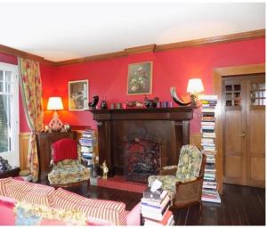 a living room with red walls and a fire place at Guest House Patrizia in Crocefieschi