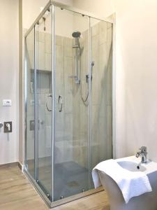 una doccia con porta in vetro accanto a un lavandino di Minisuite Zefiro-Intero appartamento ad uso esclusivo by Appartamenti Petrucci a Foligno