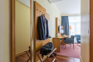 a hotel room with a mirror and a room with a desk at Strand-Hotel Hübner in Warnemünde +37 photos