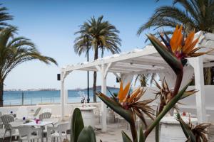 una pérgola blanca en la playa con palmeras en El Secreto del Agua, en Mar de Cristal