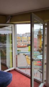 een kamer met een glazen schuifdeur en een balkon bij Hafenblick-City Apartment Husum in Husum