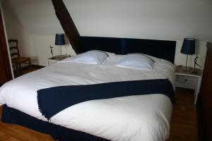 a large bed with a black and white comforter and pillows at Ferme Saint Christophe in Saint-Marcan +48 photos