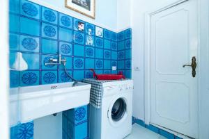 レッチェにあるLa Maison Del Baroccoの青いタイル張りのバスルーム(洗濯機、シンク付)
