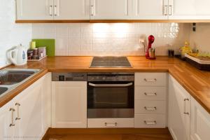 a kitchen with white cabinets and a stove and a sink at Villa Mos in Kalamata
