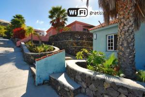 una casa con una pared de retención y algunas plantas en Bungalows & Apartamentos Morani, en Puerto Naos