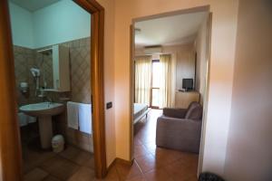 Cette chambre comprend une salle de bains pourvue d'un lavabo et d'un canapé. dans l'établissement Hotel La Maison Jolie, à Fiumicino 16 autres photos