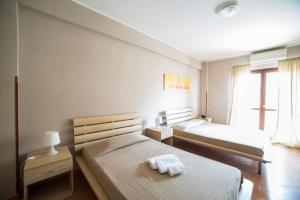 a bedroom with two beds and a window at Hotel La Maison Jolie in Fiumicino