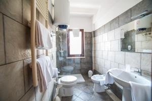 a bathroom with a toilet and a sink and a tub at Hotel La Maison Jolie in Fiumicino +18 photos