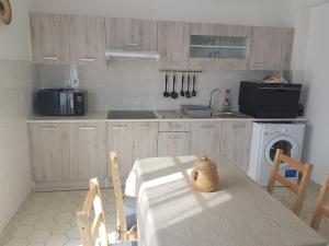 a kitchen with a table and a washing machine at Côte Landaise in Tarnos