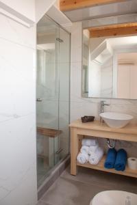 a bathroom with a glass shower and a sink at Artemis Village Apartments & Studios in Stavros