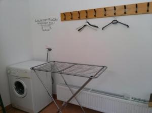 a laundry room with a washing machine and a rack with glasses at Domačija Za robom in Cerkno