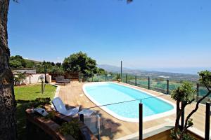 a swimming pool in a yard next to a house at Bellavista Etna in Mascali +81 photos