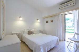 a white bedroom with two beds and a window at Capitalmoura Mouragolf Village in Vilamoura +38 photos