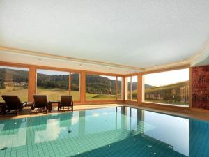 a swimming pool with a view of the mountains at derWaldfrieden naturparkhotel in Herrenschwand