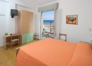 a bedroom with an orange bed and a view of the ocean at Hotel Dinarica in Marotta