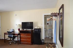 Habitación de hotel con escritorio y TV en Relax Inn, en Brunswick
