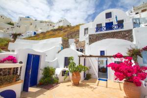 a group of white buildings with flowers in front of them at Ifestio Villas Oia in Oia +85 photos